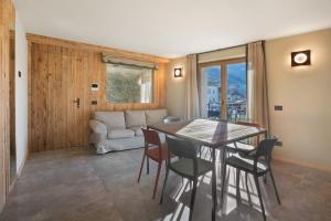 a living room with a table and chairs and a couch at Casa Ronden Mortirolo in Mazzo di Valtellina