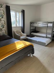 a bedroom with two bunk beds and a chair at Chez Marie et Dany in Châteaumur