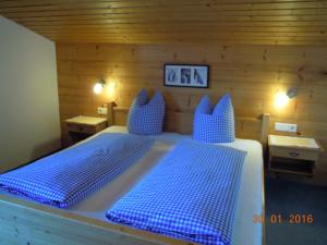 1 Schlafzimmer mit 2 Betten und blauen Kissen in einem Zimmer in der Unterkunft Jägerhof in Alpbach