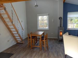 a dining room with a table and chairs and stairs at NEU! Stylisches Ferienhaus an der Südheide in Scharnhorst +6 photos