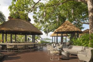 a patio with tables and chairs and gazebos at Anantara Lawana Koh Samui Resort in Chaweng +37 photos