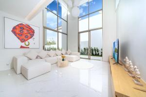 un salon avec des meubles blancs et un parapluie rouge dans l'établissement New Elegance & Tropical Luxury - 4BR Pool Villa in Lux Pride 2 V8 Residence, near Laguna, à Ban Pak Lak