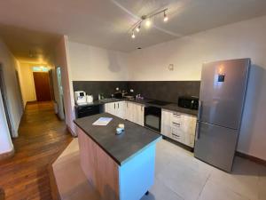 eine Küche mit Kühlschrank und Arbeitsplatte in der Unterkunft Ô Cosy, Grand T3, near train station in Briançon