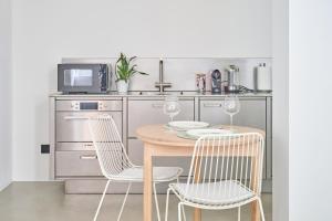 a kitchen with a table and chairs and a microwave at Ecoloft in Corso Como con parcheggio privato e gratuito in Milan