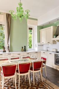 a kitchen with a table with chairs and a chandelier at Villa Angela Maria - Brienno by LoveComo in Brienno