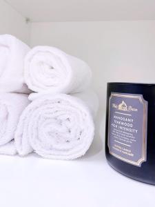 a pile of white towels on a shelf with a candle at Y Vi Vinhomes Grand Park in Long Bình