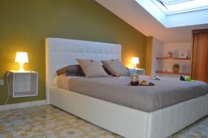 a bedroom with a large bed with two lamps at Un Tetto Di Stelle Deluxe Home in Salerno