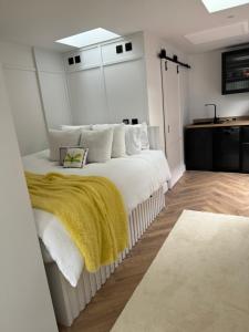a bedroom with a white bed with a yellow blanket at Pleasant Place in Lowestoft