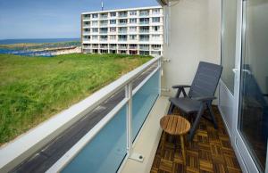 ein Balkon mit einem Stuhl und Blick auf ein Gebäude in der Unterkunft bij Miep in Egmond aan Zee
