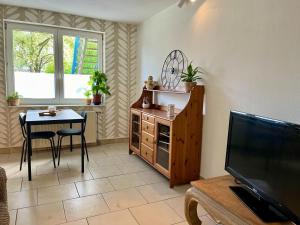 a living room with a table and a television at Petit Havre in Namur