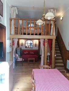 a living room with a red couch and a staircase at Appartement Eaux-Bonnes in Eaux-Bonnes