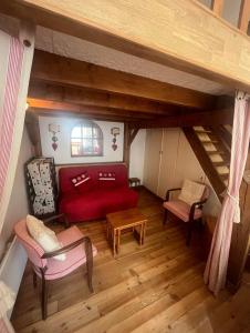 a living room with a red couch and chairs in a attic at Appartement Eaux-Bonnes in Eaux-Bonnes