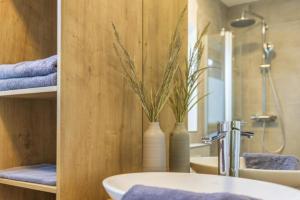 a bathroom with a sink and a vase with a plant at Deich 71 in Borkum +63 photos