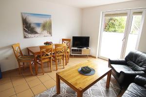 a living room with a table and a couch at Haus Rena am Südstrand in Borkum