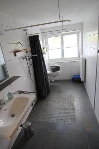 a bathroom with a shower curtain and a sink at Haus Rena am Südstrand in Borkum
