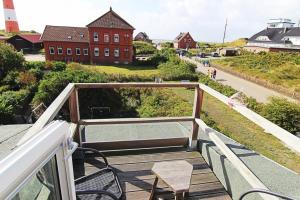 a balcony with chairs and a lighthouse in the background at Haus Rena am Südstrand in Borkum