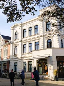 a white building with people walking in front of it at Villa Scherz - stilvoll, zentral, ruhig, EG in Borkum +12 photos
