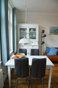 a kitchen with a white table with chairs and a couch at Villa Scherz - stilvoll, zentral, ruhig, EG in Borkum