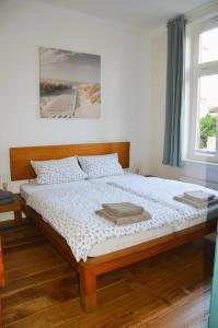a bedroom with a bed with a wooden head board at Villa Scherz - stilvoll, zentral, ruhig, EG in Borkum