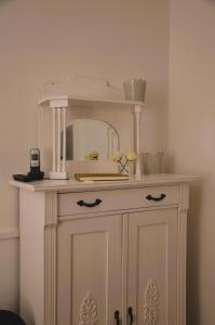a white cabinet with a mirror on top of it at Villa Scherz - stilvoll, zentral, ruhig, EG in Borkum