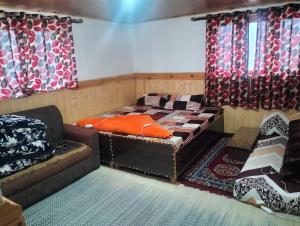 a room with a bed and a couch and curtains at New Buddha Homestay By StayApart in Tabo