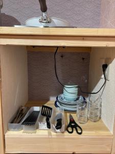 un mobiletto di legno con uno scaffale con forbici e piatti di 箱根 望湖 箱根中心 神社 海賊船徒歩圏 a Hakone Altre 19 foto