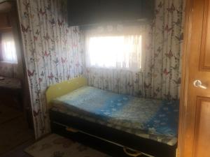 a small bed in a room with a window at Duży kemping in Ustronie Morskie