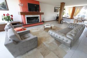 a living room with two couches and a fireplace at Hotel Villa Aconchego de Gramado in Gramado