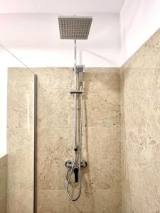 a shower with a shower head in a bathroom at Riverside ApartHotel by InnTime in Cluj-Napoca +63 photos