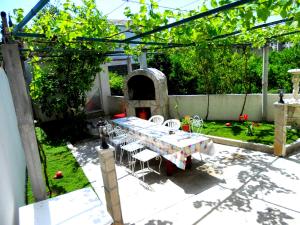 a table and chairs in a garden with a table and a table and a table at Apartments Marijana in Tivat