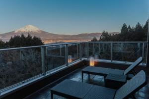 a balcony with a table and chairs and a mountain at Wellリゾート富士 in Gotemba