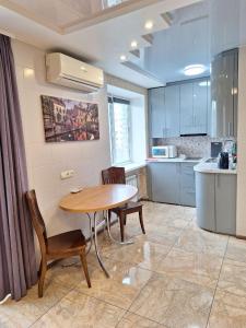 eine Küche mit einem Holztisch und Stühlen in einem Zimmer in der Unterkunft 1-комнатная на левом берегу Днепра in Dnipro