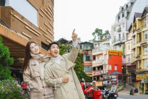 a man and a woman walking down a street at Nature Hotel - Win Happy in Da Lat