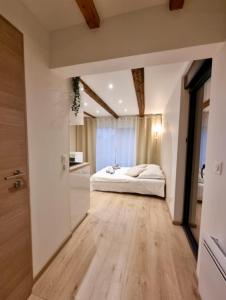 Suite cosy indépendante Evasion env Colmar في فينتزنهايم: غرفة نوم بسرير أبيض وأرضية خشبية