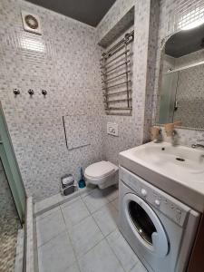 ein Badezimmer mit Waschmaschine und Waschbecken in der Unterkunft 1-комнатная на левом берегу Днепра in Dnipro
