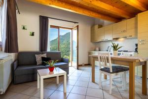 a kitchen and living room with a couch and a table at Apartments in Tremosine - Gardasee 22254 in Pieve