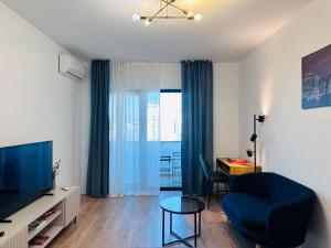 a living room with a blue couch and a tv at ELA Cotroceni Residence - self check in & free parking in Bucharest