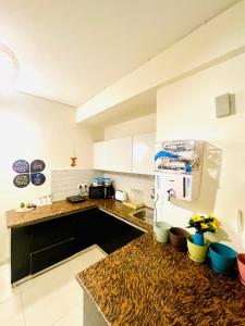 Una cocina con encimera y refrigerador. en Blues - Aashray, en Noida