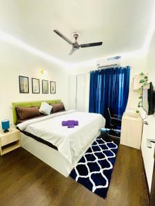 Un dormitorio con una cama y un ventilador de techo. en Blues - Aashray, en Noida