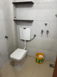 a bathroom with a white toilet in a stall at Shivaksh Rental Flats and Rooms- Best Hotel in Bhawani Mandi in Bhawāni Mandi