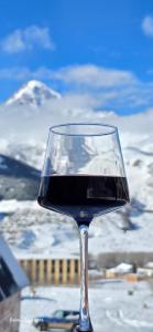 een glas rode wijn bovenop een tafel bij Elia Hut Kazbegi in Kazbegi