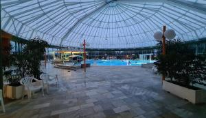 a large building with a swimming pool with a glass ceiling at Ferienwohnung Delja in Aulendorf