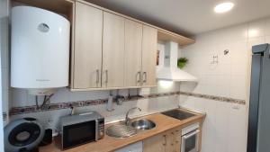 a kitchen with a sink and a microwave at Ventana a Granada de Marijose in Las Gabias