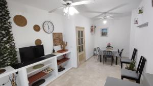 a living room with a tv and a dining room at Ventana a Granada de Marijose in Las Gabias