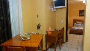 a dining room with a table and a room with a bed at Lodge Takini 4 in Kourou