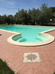 a large swimming pool with blue water at Le Coccole Del Trasimeno in Tuoro sul Trasimeno