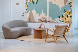un soggiorno con una sedia e un tavolo di Strandhotel Klitrosen a Fjerritslev