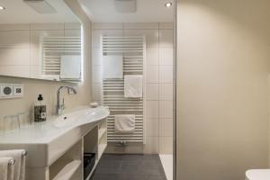 a white bathroom with a sink and a shower at Landgasthof Rössle - Beim Kräuterwirt in Oberstaufen +42 photos