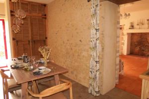 Clermont-CréansGîte écoconçu charmant proche zoo de la Flèche的配有木桌椅的餐厅