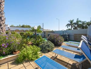 a patio with a blue bench and some plants at Coral Apartment In Porto Cesareo in Torre Lapillo